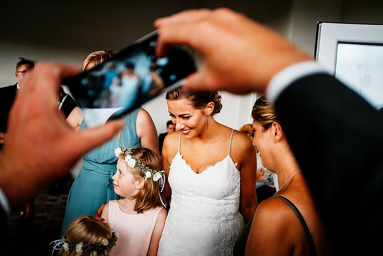 Hochzeitsfotografie auf der Hochzeitsfeier, die Braut wird mit einem Smartphone fotografiert